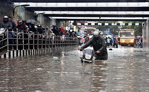Local residents struggle to cross the flooded Ganeshapuram subway at vyasarapadi during following incessant rains. (Photo | P Jawahar)