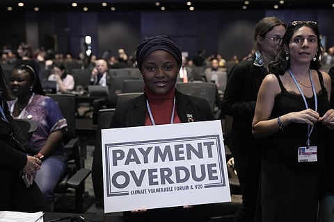 Nakeeyat Dramani Sam, of Ghana, holds a sign that reads 'payment overdue' at the COP27 UN Climate Summit, Friday, Nov. 18, 2022, in Sharm el-Sheikh, Egypt. (Photo | AP)