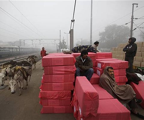 Donkeys carrying debris walk past people waiting for a train on a foggy morning in New Delhi. (File Photo | AP)