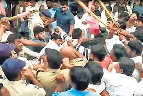 Police try to break up a clash between TRS and BJP workers in Palivela village on Tuesday