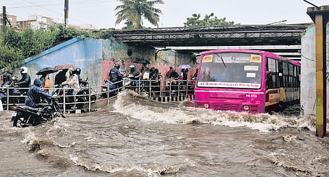 Passengers being evacuated from an MTC bus that got stuck in the Ganeshapuram Subway in Vyasarpadi; a worker pumps out floodwater in Pulianthope