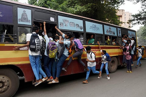 Schoolchildren hang out of a crowded bus at Vepery in Chennai. (Photo | R Satish Babu, EPS)