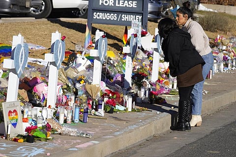 Mourners stand along the makeshift memorial to the victims of a weekend mass shooting at a nearby gay nightclub on November 22, 2022, in Colorado Springs | PTI