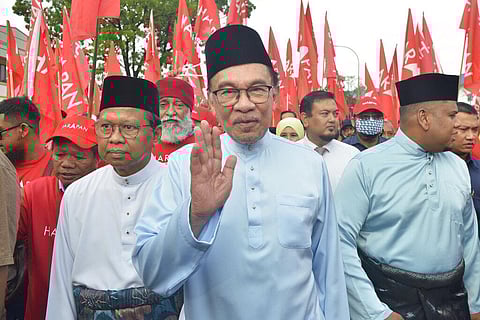 Malaysia's then opposition leader Anwar Ibrahim, (C), waves to his supporters in Tambun, Malaysia, Nov. 5, 2022. (File Photo | AP)