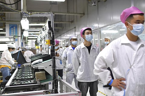 Workers line up to get tested for COVID-19 at the Foxconn factory in Wuhan (File Photo | AP)