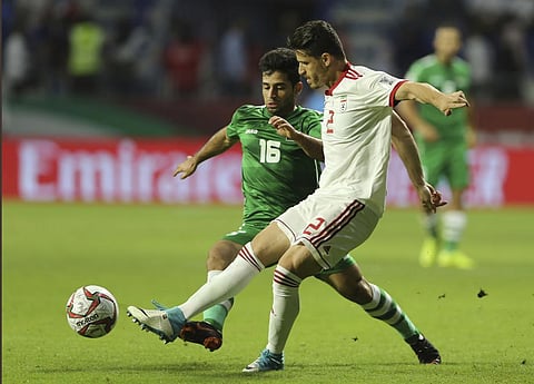 Voria Ghafouri, right, fights for the ball with Iraqi midfielder Hussein Ali, during the AFC Asian Cup soccer match at the Al Maktoum Stadium in Dubai, Jan. 16, 2019. (Photo | AP)
