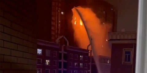 In this image taken from video, firefighters spray water on a fire at a residential building in Urumqi in western China's Xinjiang Uyghur Autonomous Region. (Photo |AP)
