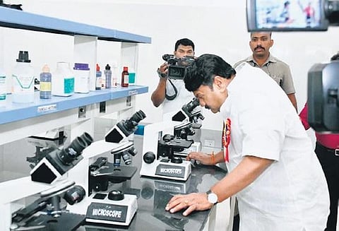 Minister Talasani Srinivas Yadav looks into a microscope after inaugurating the veterinary clinical complex at PVNRTVU. (Photo | EPS)