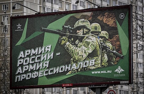 A photograph taken on October 24, 2022 shows a poster displaying Russian soldiers with a slogan reading 'Army of Russia - Army of professionals' decorating a street in Moscow. (Photo | AFP)
