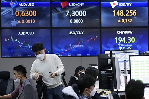 A currency trader passes by the screens showing the foreign exchange rates at the KEB Hana Bank headquarters in Seoul, South Korea. (Photo | AP)