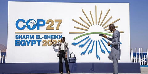 People pose for a photograph at the entrance of the COP27 U.N. Climate Summit, Sunday, Nov. 6, 2022.(Photo | AP)