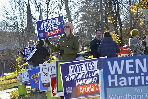 A woman stands outside a polling station in Vermont encouraging voters to vote yes to make abortion a constitutional right in the state, Nov. 8, 2022. (Photo | AP)
