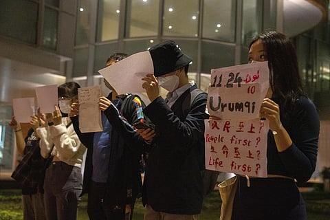 Protesters hold up white paper some with writings commemorating the Nov 24 deadly Urumqi fire during a gathering at the University of Hong Kong in Hong Kong, Nov. 29, 2022. (Photo | AP)