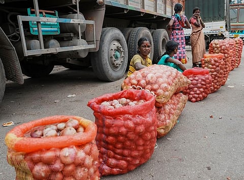 Roadside vendors wait for customers to sell onion, in Bengaluru. (Photo | PTI)