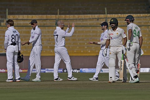 England's Jack Leach, center, celebrates with teammates after taking the wicket of Pakistan's Abdullah Shafique, second right, during the first day of third test cricket match. (Photo | AP)