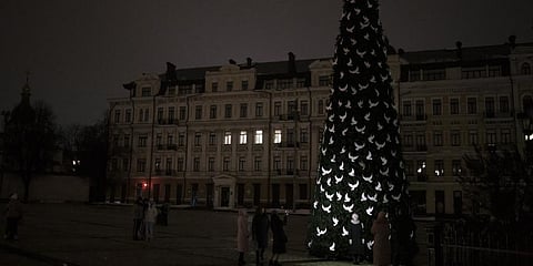 Ukrainians take photos of a newly built Christmas tree as partial power outages continue in Kyiv, Ukraine, Saturday, Dec. 17, 2022. (Photo | AP)