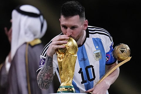 Argentina's Lionel Messi kisses the World Cup trophy as he holds the Golden Ball award for best player of the tournament. (Photo | AP)