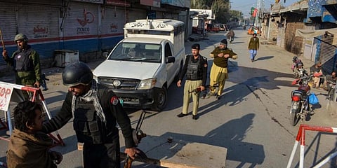 Police stand guard along a road they blocked after Pakistan Taliban militants seized a police station in Bannu and took several hostages after overpowering their jailers.(Photo | AFP)