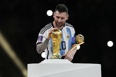 Argentina's Lionel Messi pats the trophy after winning the World Cup final match against France at the Lusail Stadium in Qatar. (Photo | AP)