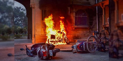 Vehicles set on fire during a protest by Allahabad University students in Prayagraj, Dec. 19, 2022. (Photo | PTI)