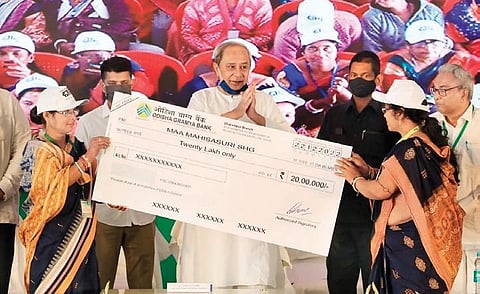 CM Naveen Patnaik presents cheque to members of a SHG at Balasore on Thursday