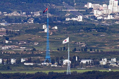 Flags of North Korea, rear, and South Korea, front, flutter in the wind as pictured from the border area between two Koreas in Paju, South Korea, on Aug. 9, 2021. (File photo | AP)