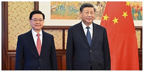 In this photo released by Xinhua News Agency, Chinese President Xi Jinping, right, stands next to Hong Kong Chief Executive John Lee. (Photo | AP)