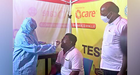 Tamil Nadu Minister for Medical and Family Welfare Ma. Subramanian inspects a passenger undergoing for COVID-19 test, at the Chennai International airport. (Photo | Martin Louis, EPS)