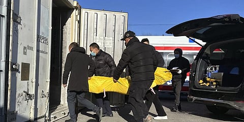 Workers transfer a body into a container for storage at a crematorium in Beijing, Saturday, Dec. 17, 2022. (Photo | AP)