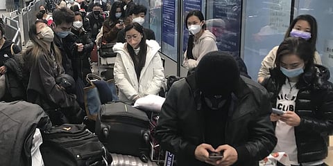 Inbound travelers wait for hours to board buses to leave for quarantine hotels and facilities from Guangzhou Baiyun Airport in southern China.(Photo | AP)