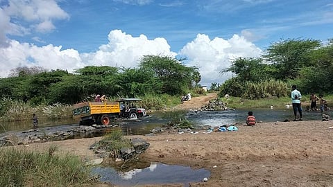 A tractor crosses over the Vellaru river passing between Thiruvalandurai and Keelakalpoondi, in the absence of a bridge | Express
