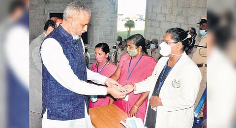Assembly Speaker Vishweshwar Hegde Kageri collects a face mask before attending the winter session at Suvarna Vidhana Soudha in Belagavi on Monday