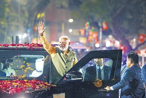 Prime Minister Narendra Modi waves at supporters during his election campaign roadshow for Gujarat Assembly polls, in Ahmedabad on Friday. (Photo| PTI)