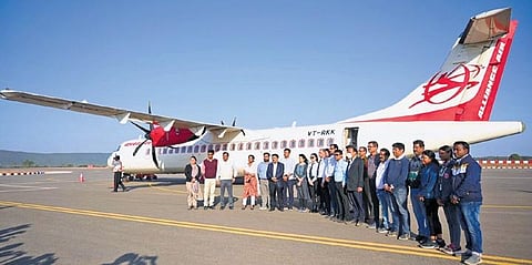Officials pose for photograph after trial landing of ATR-72 aircraft at the airport