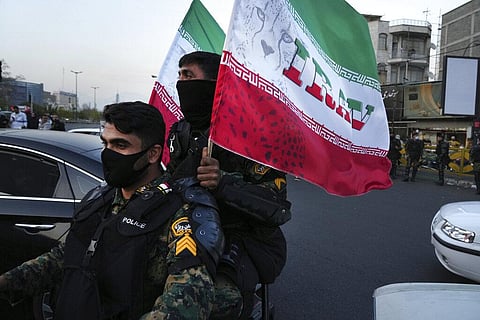 Anti-riot police officers carry representations of the Iranian flag | AP