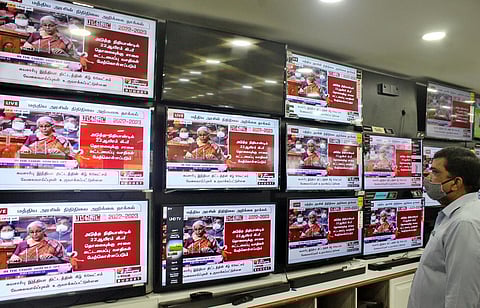 A person at a showroom watch the live telecast of Finance Minister Nirmala Sitharaman's tabling of the Union Budget. (Photo | U Rakesh Kumar, EPS)