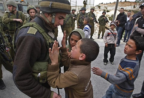 A Palestinian youth tries to push past an Israeli soldier during a demonstration against Israel's controversial separation barrier in the village of Maasarah. (Photo | AP)