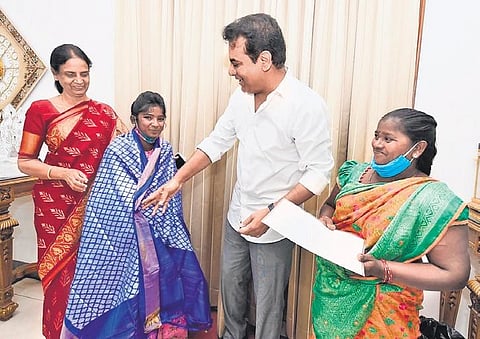 IT & Industries Minister KT Rama Rao hands over papers for a 2BHK and an autorickshaw to Nalgonda college girl Sabita, on Wednesday as Education Minister Sabitha Indra Reddy and the girl’s mother are