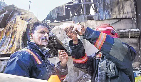 A Fire and rescue services staffer applying Lignocaine Hydrochloride gel on the face of a colleague who suffered burns | A Sanes h