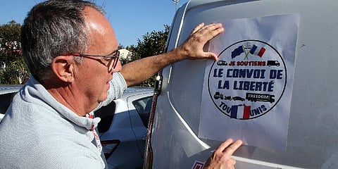 A man puts a poster reads 'Liberty Convoy' on a van before leaving for Paris , in Bayonne, southwestern France, Wednesday, Feb.9, 2022. (Photo | AP)