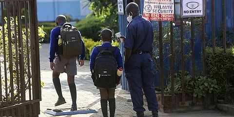 A security guard checks the temperature of children entering the schools premises at a government school in Harare, Wednesday, Feb, 9, 2022.(Photo | AP)