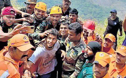 Babu surrounded by Army jawans atop Kurumbachi hills in Cherad near Malampuzha, Palakkad, after being rescued on Wednesday