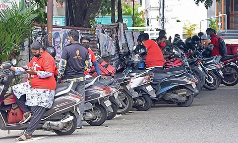 Several online food delivery executives waiting outside a restaurant at Bakery junction in Thiruvananthapuram | B P Deepu