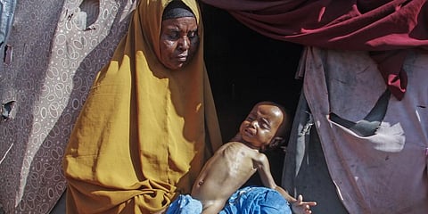 A woman holds her 9 month old grandchild outside the tent where they now live at a makeshift camp on the outskirts of the capital Mogadishu, Somalia Friday, Feb. 4, 2022.(Photo | AP)