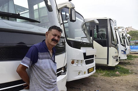Royson Joseph, owner of Royal Travels, stands next to his buses parked at Manapatiparambu in Kochi. (Photo | Albin Mathew, EPS)
