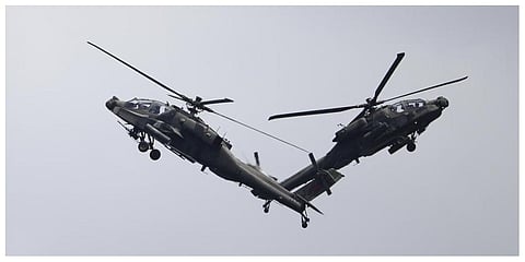 A pair of Republic of Singapore Air Force (RSAF) AH-64D Apache attack helicopters perform aerial maneuvers during the Singapore Airshow 2022 at Changi Exhibition Centre in Singapore. (Photo: AP)