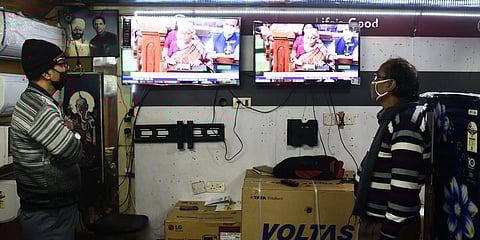 Staff at an electronics store in Delhi watch Finance Minister Nirmala Sitharaman present the Union Budget 2022. (Photo| Parveen Negi, EPS)