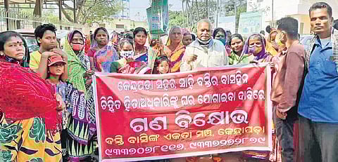 Slum dwellers staging protest in front of the Collector’s office on Tuesday | Express