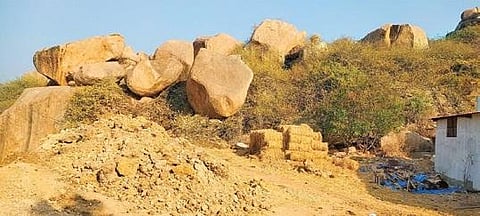 Loose earth is dumped to flatten the area around the famous Khajaguda rock formation, above, while empty trucks