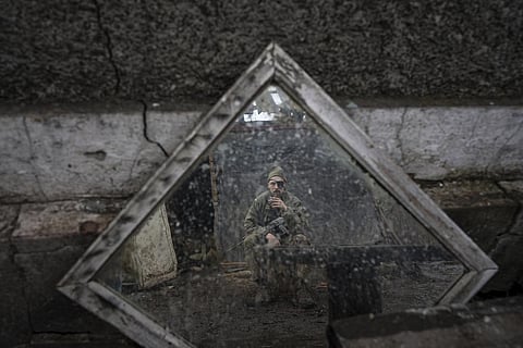 A Ukrainian serviceman is reflected in a mirror as he smokes a cigarette on a position at the line of separation between Ukraine and rebel held territories near Zolote ( (AP Photo | Evgeniy Maloletka)